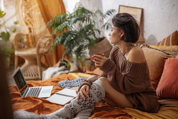 Pretty young woman is looking on laptop screen