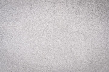 Gray concrete wall texture painted with white. The old white color that has been fading and peeling off. Texture of old dirty concrete wall for background.