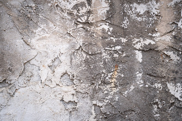 Gray concrete wall texture painted with white. The old white color that has been fading and peeling off. Texture of old dirty concrete wall for background.