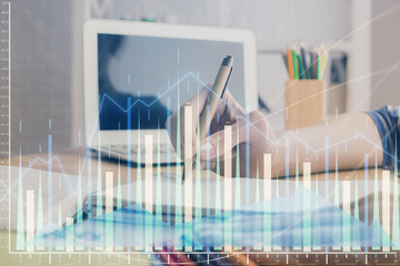 Financial forex charts displayed on woman's hand taking notes background. Concept of research....