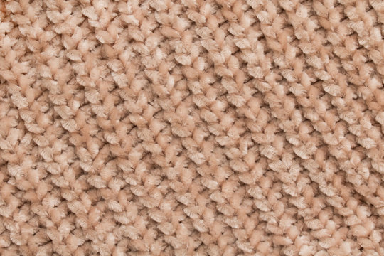 Fluffy tender baby beige fabric with waves and folds. Soft pastel textile texture. Folds on a soft cloth.