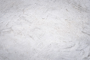 Gray concrete wall texture painted with white. The old white color that has been fading and peeling off. Texture of old dirty concrete wall for background.