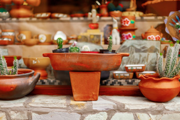 Close-up of orange ceramic vessels in the window of a souvenir shop