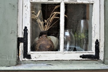 Riga, Latvia, November 2019. An interesting still life behind the glass of an old window.