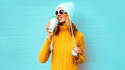 Winter portrait smiling young woman drinking coffee looking away wearing yellow knitted sweater,...