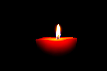 Closeup of burning candle isolated on black background