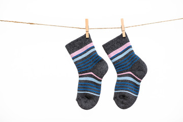 A pair of baby socks hanging on a clothesline isolated on white background