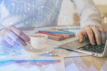 Forex graph with businessman working on computer in office on background. Concept of hardworking....