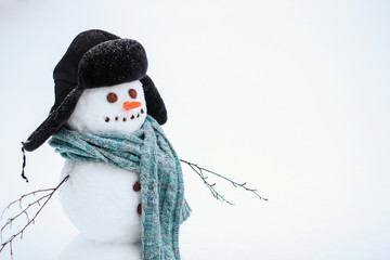  Snowman in a blue knitted scarf and hat copy space.