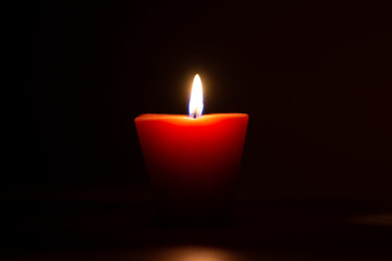 Closeup of burning candle isolated on black background