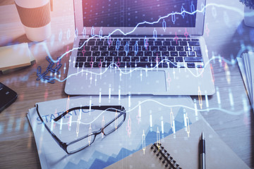 Financial graph colorful drawing and table with computer on background. Multi exposure. Concept of...