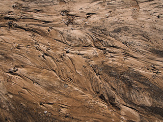 Sand texture background with traces of water flowing
