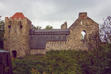 Fototapeta premium Ruins of ancient Sigulda Medieval Castle, Latvia. It was built at an early stage of the conquest of the Baltic states by the crusaders. Summer cloudy and rainy day. Soft focus.