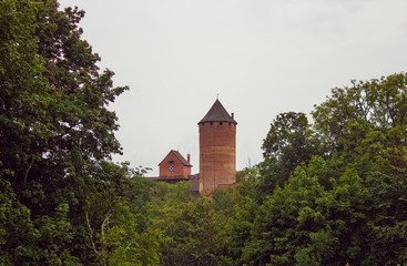 Fototapeta premium View on the tower of medieval Turaida Castle in cloudy, foggy and rainy day, Sigulda, Latvia. It is reconstructed castle, which was founded in 1214. Touristic Place. Soft selective focus