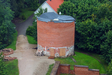 Naklejka premium Aerial view on the small tower from the main big tower of medieval Turaida Castle in cloudy, foggy and rainy day, Sigulda, Latvia. It is reconstructed castle, which was founded in 1214. Soft focus
