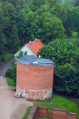 Naklejka premium Aerial view on the small tower from the main big tower of medieval Turaida Castle in cloudy, foggy and rainy day, Sigulda, Latvia. It is reconstructed castle, which was founded in 1214. Soft focus