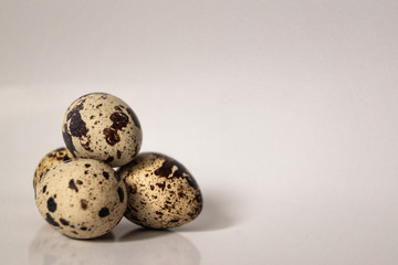 Three quail eggs on a white background stock photo