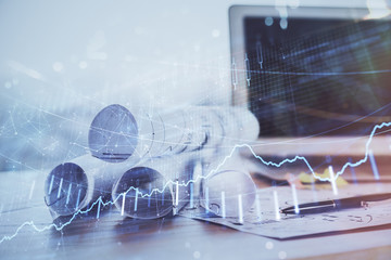 Stock market graph on background with desk and personal computer. Double exposure. Concept of financial analysis.