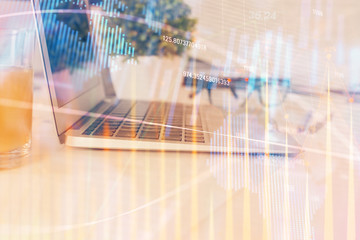 Forex graph hologram on table with computer background. Multi exposure. Concept of financial markets.