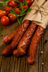 Kabanos or Cabanossi Thin Dry Smoked Polish Sausage on Wooden Background. Selective focus.