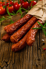 Kabanos or Cabanossi Thin Dry Smoked Polish Sausage on Wooden Background. Selective focus.