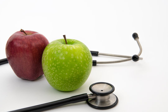 red and green apple with stethoscope in isolated white background. healthy diet concept