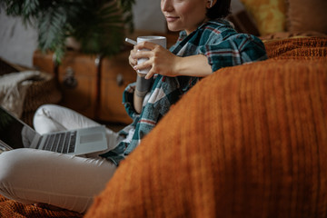 Pretty young woman is holding hot drink in hands