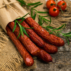 Kabanos or Cabanossi Thin Dry Smoked Polish Sausage on Wooden Background. Selective focus.