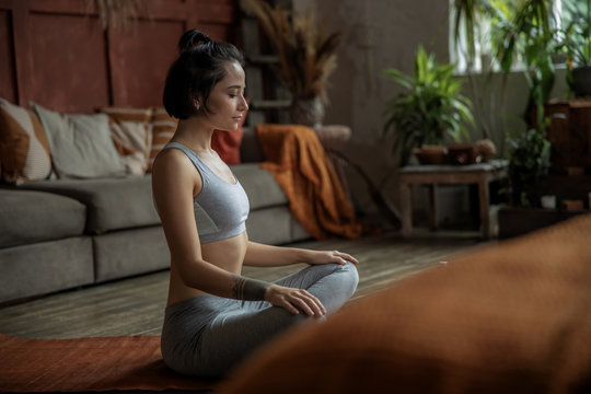 Beautiful Young Woman Practicing Yoga At Home