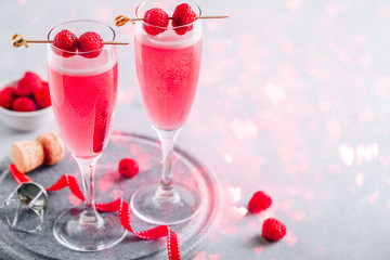 Pink cocktail with champagne or prosecco and fresh raspberries for  Valentine's day.
