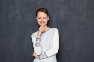 Portrait of happy joyful young woman touching chin with hand