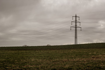 Strommast zwischen den Feldern, bedeckter Himmel