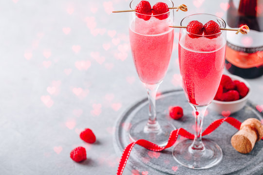 Pink cocktail with champagne or prosecco and fresh raspberries for  Valentine's day.