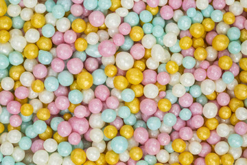 Fototapeta na wymiar background of colorful sugar sprinkles in blue, pink, white and yellow
