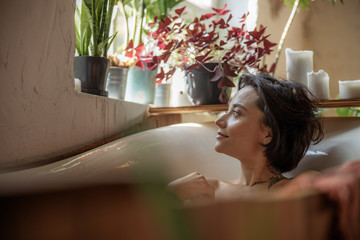 Beautiful girl in a bathtub with candles