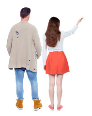 Back view of a stylish couple pointing.