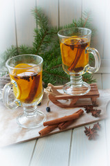 Mulled wine with slice of orange and spices. Conceptual bright card in yellow, blue and white. Vertical image