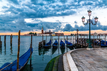 Gondolas docked in Saint Mark square with San Giorgio Maggiore island