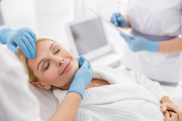 Smiling adult lady during the examination of a specialist