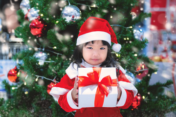 Portrait of cute asian little girl wear santa dress happy near christmas tree,Thailand kid join christmas festival
