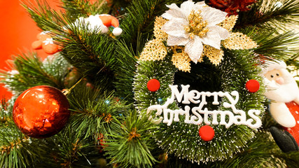 Christmas toy on the branches of a New Year tree. Christmas tree decorated with a wording  Merry Christmas           