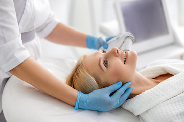 Adult lady looking on beautician during procedure