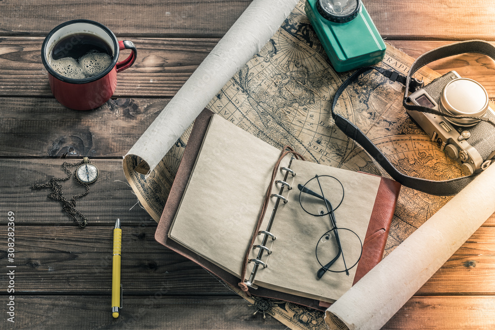 Poster a map spread out on the table with a cup of hot tea and useful items for the trip. vintage style. pl