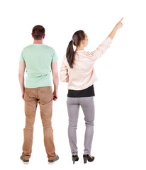 Back view of a stylish couple pointing.