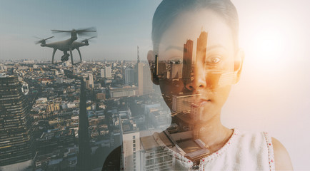 Double exposure of businesswoman and cityscape with Drone quad copter with high resolution digital...