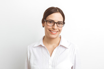 Young business woman with glasses smiling on a white background. Portrait of a friendly female manager in shirt.