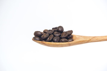 Coffee bean in the wooden spoon isolated on a white background.