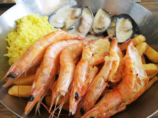Mediterranean dishes of fried shrimp mussels in a sauce garnished with rice