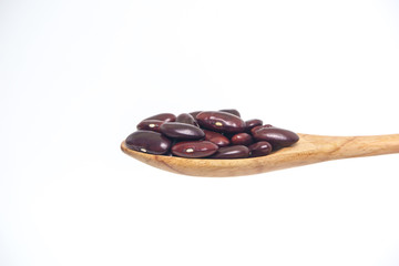 Red kidney beans grain in the wooden spoon isolated on a white background.