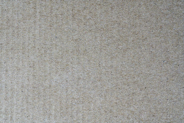 Light brown texture from sheet of recycled cardboard. Close up detail view of abstract recycled eco-friendly material pattern background.